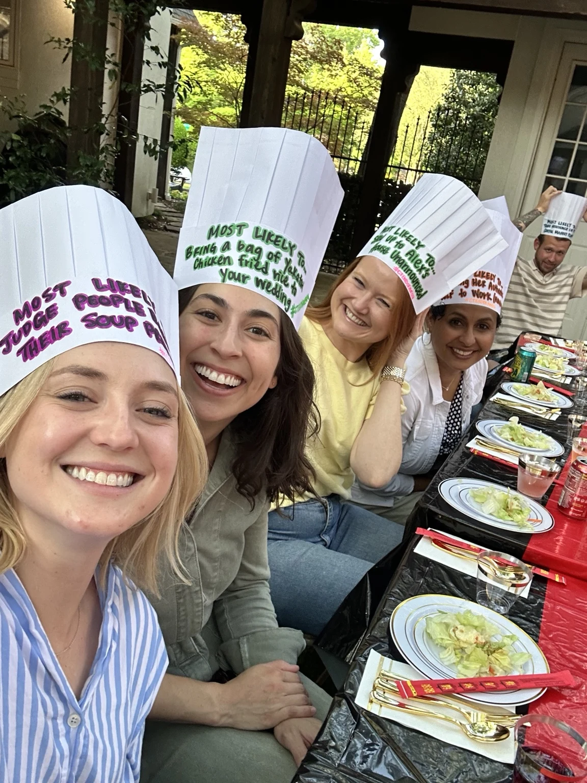 Friends smiling together in chef hats at a private hibachi celebration